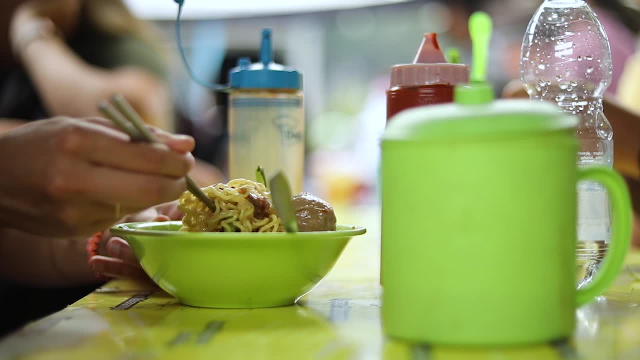Ripresa di qualcuno che mangia il suo cibo indonesiano e gioca con i suoi noodles