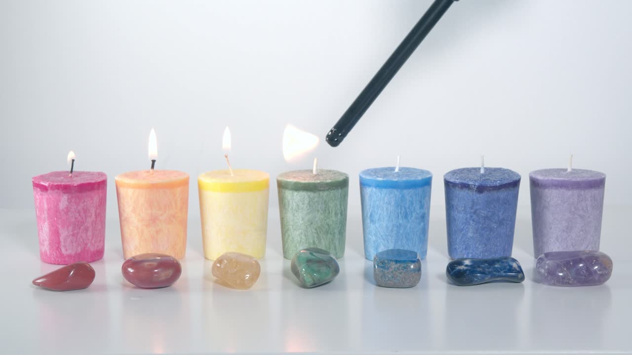 Lighting the seven chakra system candles with gemstones