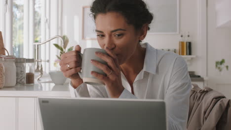 Hermosa-Mujer-De-Raza-Mixta-Usando-Una-Computadora-Portátil-Trabajando-En-Casa-En-La-Cocina-Escribiendo-Correo-Electrónico-Tomando-Café-Disfrutando-De-La-Tecnología-De-Comunicación-Moderna