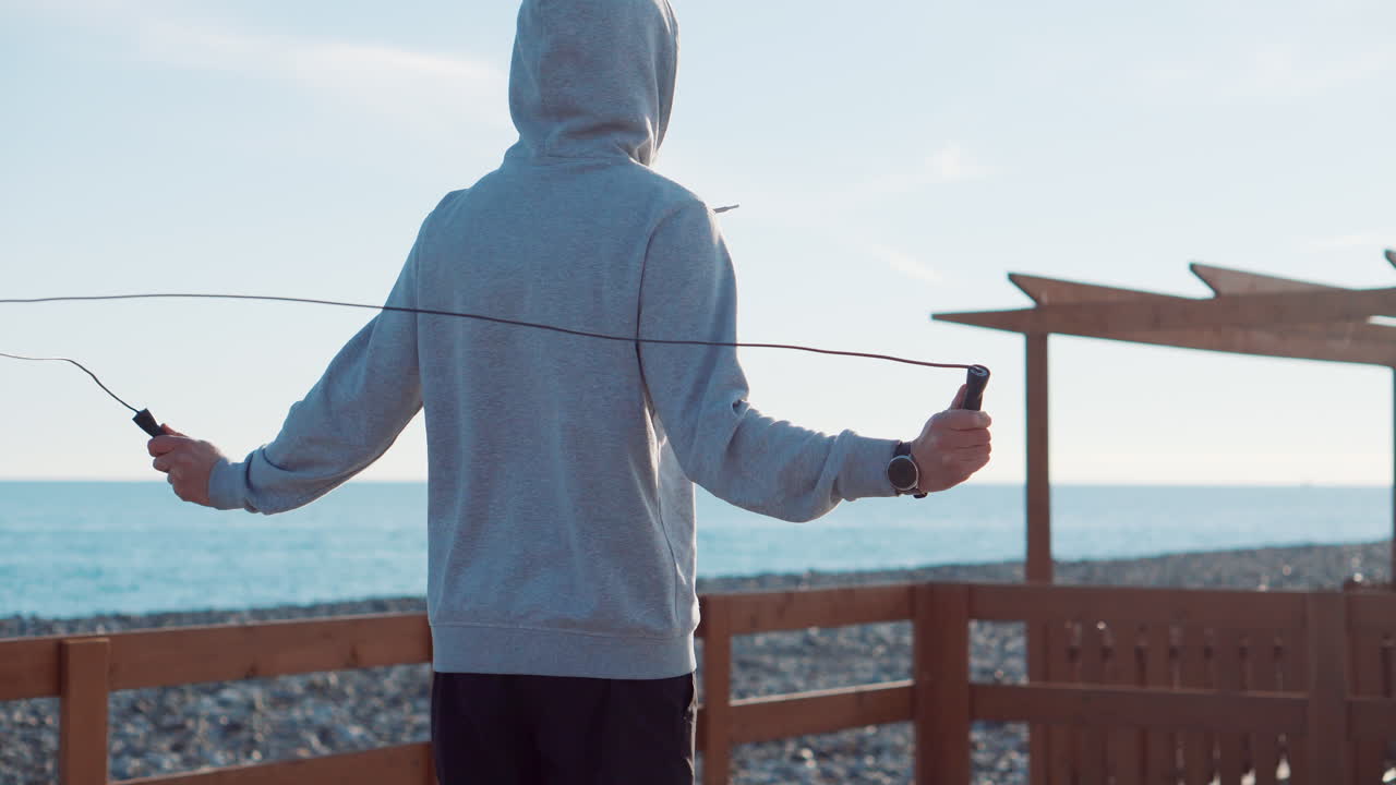 해변에서 로프를 뛰어넘는 남자