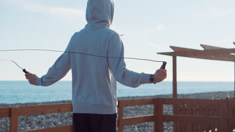hombre saltando la cuerda en la playa