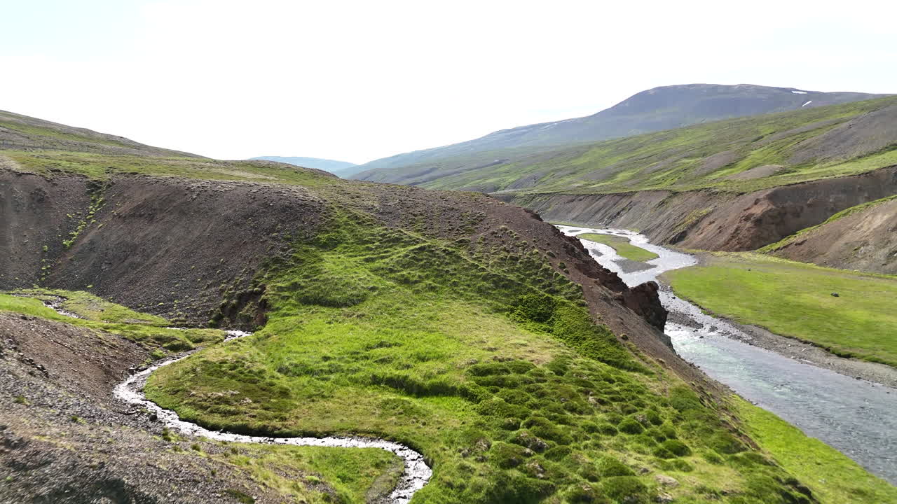 Aerial view of a river winding through a canyon in Skagi Peninsula, showing flowing water and raw Icelandic terrain