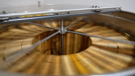 organic honey frames spinning in the centrifuge apparatus. special device for extracting honey at bee farms at work.