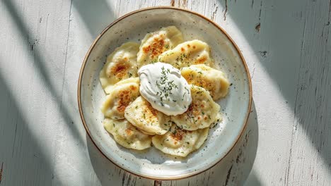 plato de albóndigas tradicionales de pierogi con guarnición de crema agria