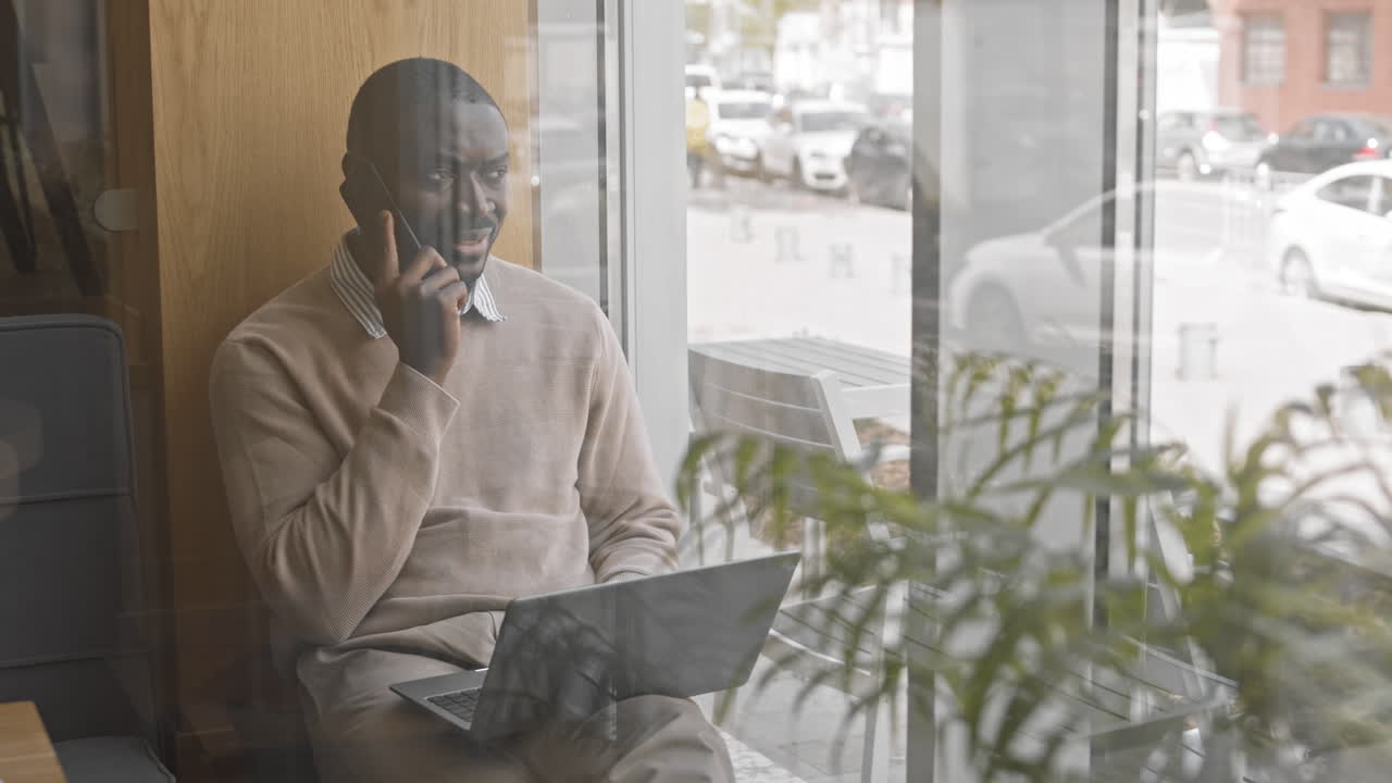 Afro American Man Having Business Phone Call in Cafe