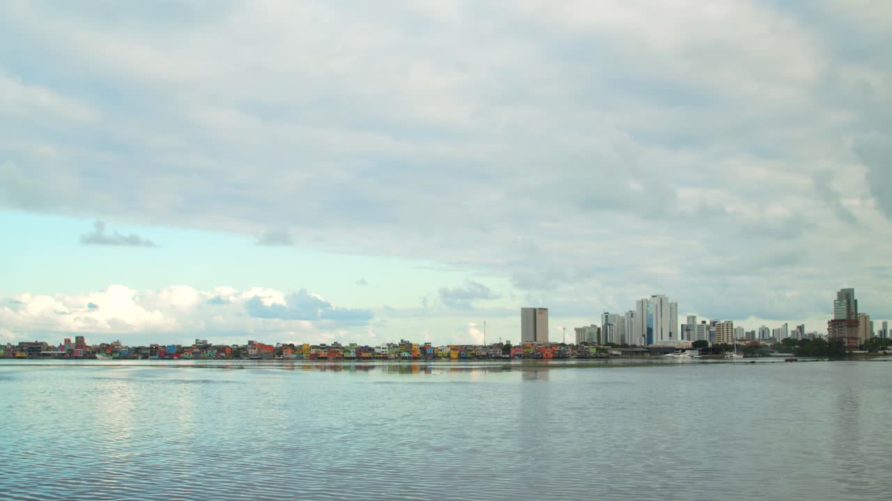 화창하고 흐린 날 호수 근처의 다채로운 빈민가 주택과 건물