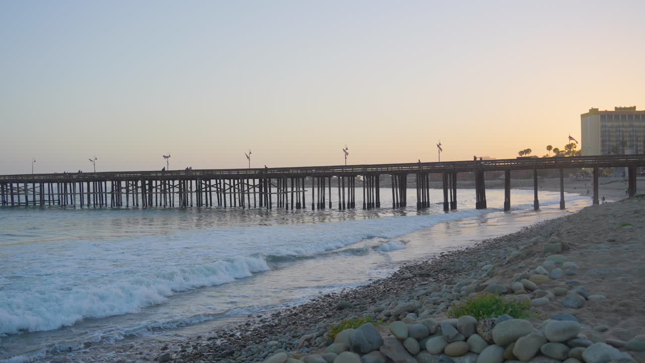 toma panorámica de las olas del océano pacífico rompiendo a lo largo de las costas del muelle ventura mientras se pone el sol ubicado en el sur de california