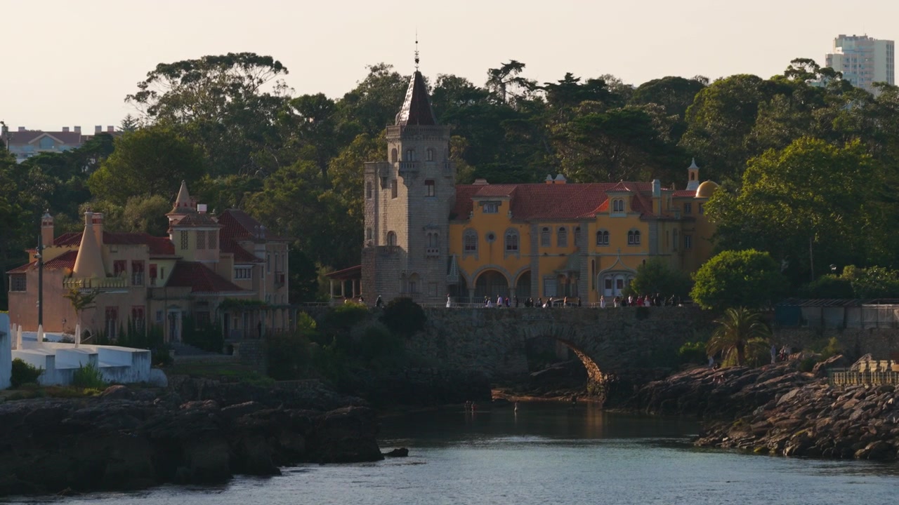 Muzeum Condes de Castro Guimarães s výhledem na skalnatý pobřežní záliv v Cascais, Portugalsko, během teplého světla zlaté hodinky