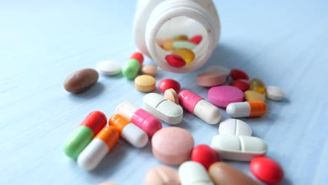 assorted pills and capsules scattered from a bottle