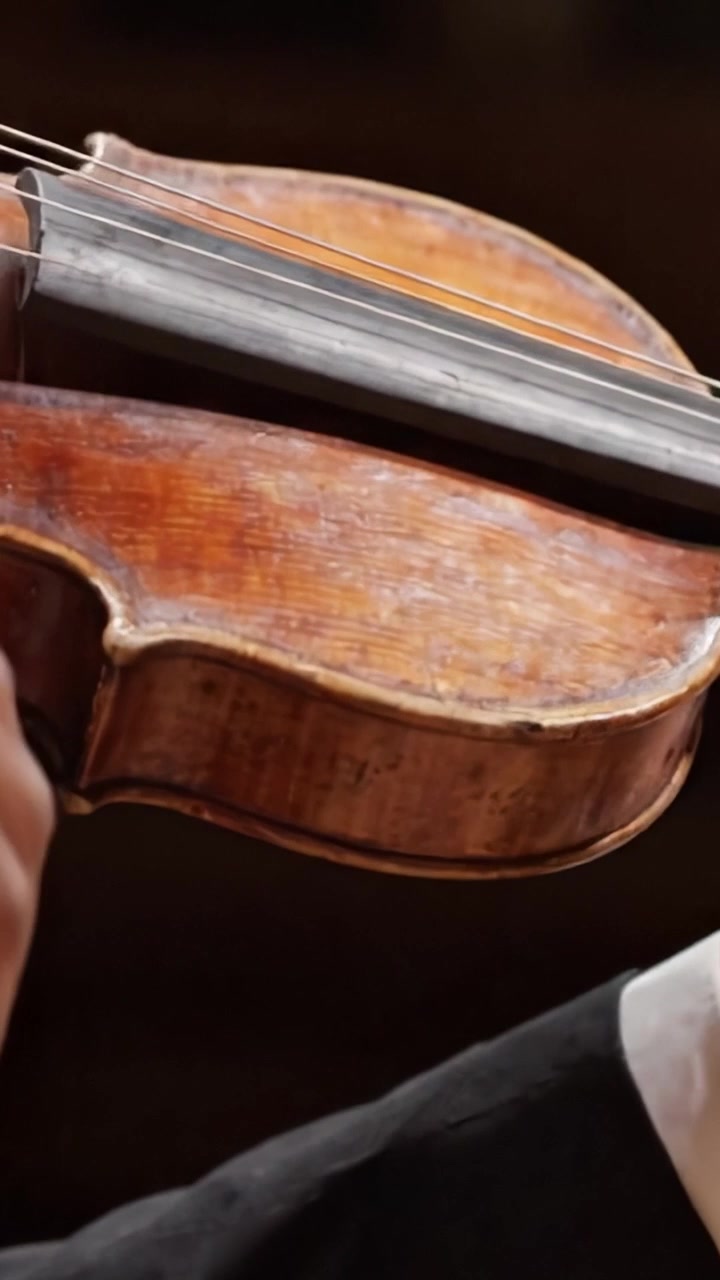 A Close-Up View of a Violin in Use: The Artistry of Music Captured in Detail, Highlighting the Rich Texture and Craftsmanship of the Instrument in Performance