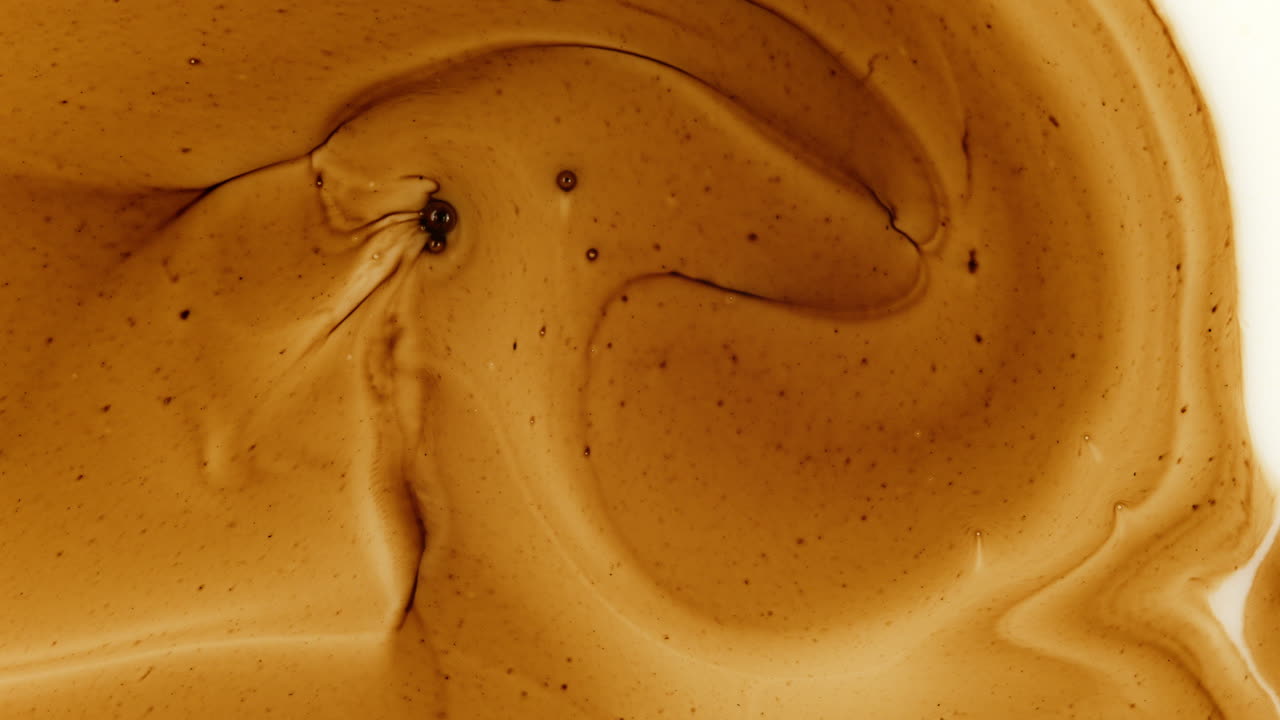 video de movimiento de mezcla de tinta de color dorado en fluido blanco