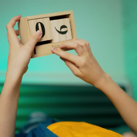 boy holds wooden blocks. wooden cube calendar