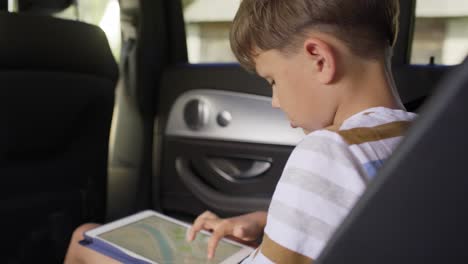 video de un niño con una tableta durante un viaje por carretera