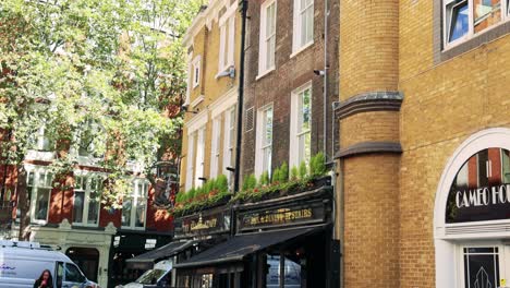 people walking past a lively london pub