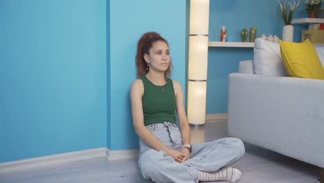 una mujer exhausta y reflexiva apoyando la cabeza contra la pared.