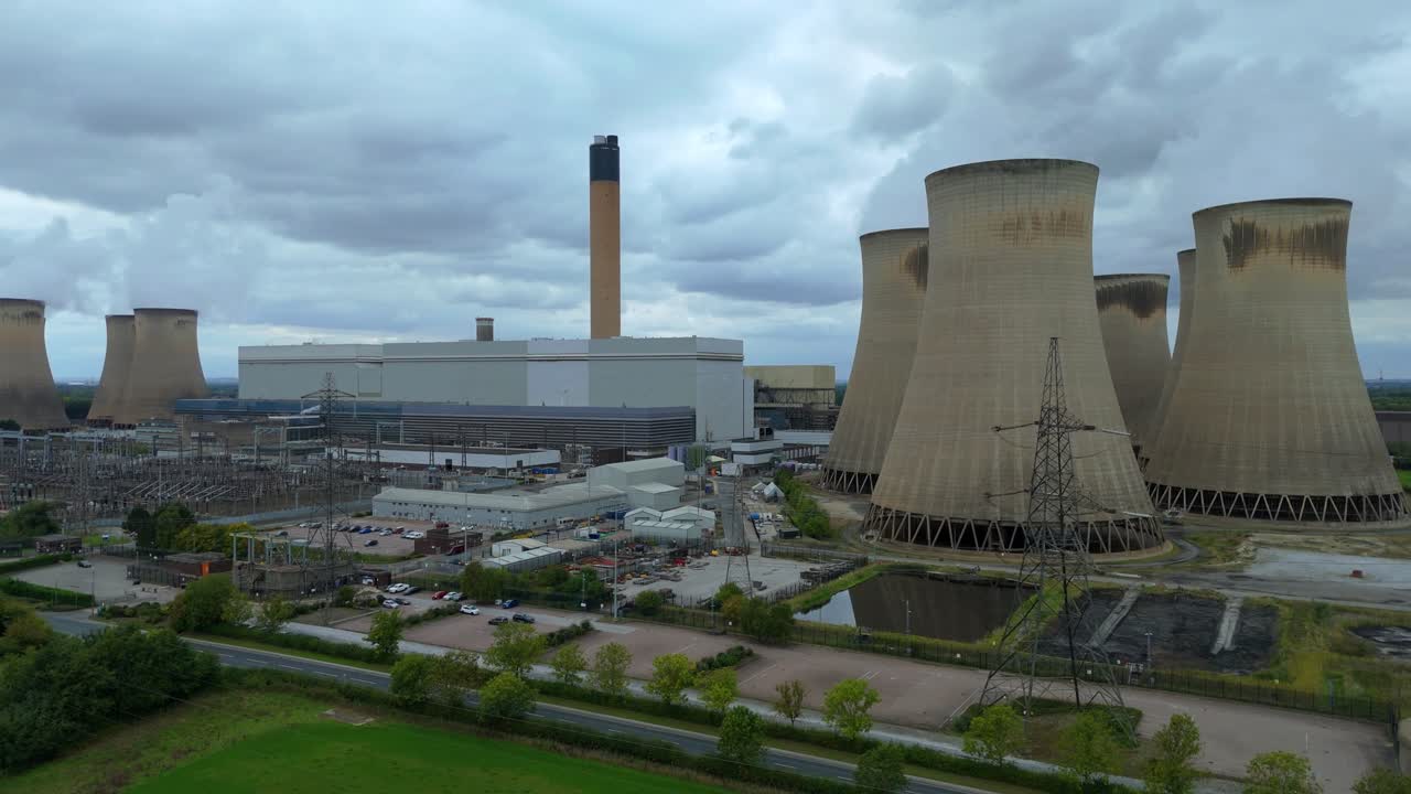 Ripresa cinematografica dall'alto di ciminiere di centrali termoelettriche e infrastrutture di rete nella pianura dello Yorkshire