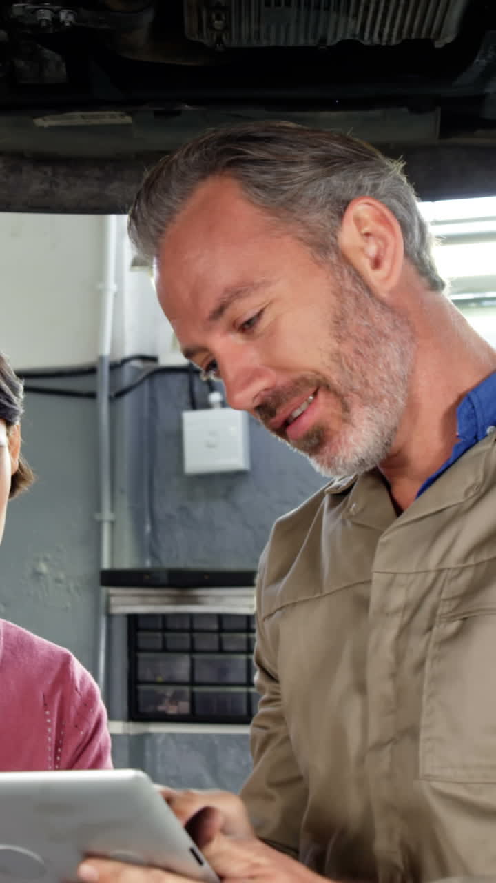 mecánico mostrando al cliente el problema con el coche