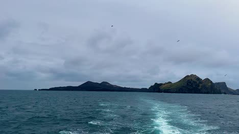 Estela-De-Barco-Con-Vistas-A-Vestmannaeyjar-Bajo-Un-Cielo-Nublado,-Temperamental-Y-Sereno