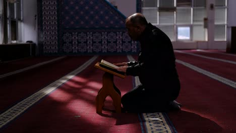 man reads the quran in a mosque during ramadan