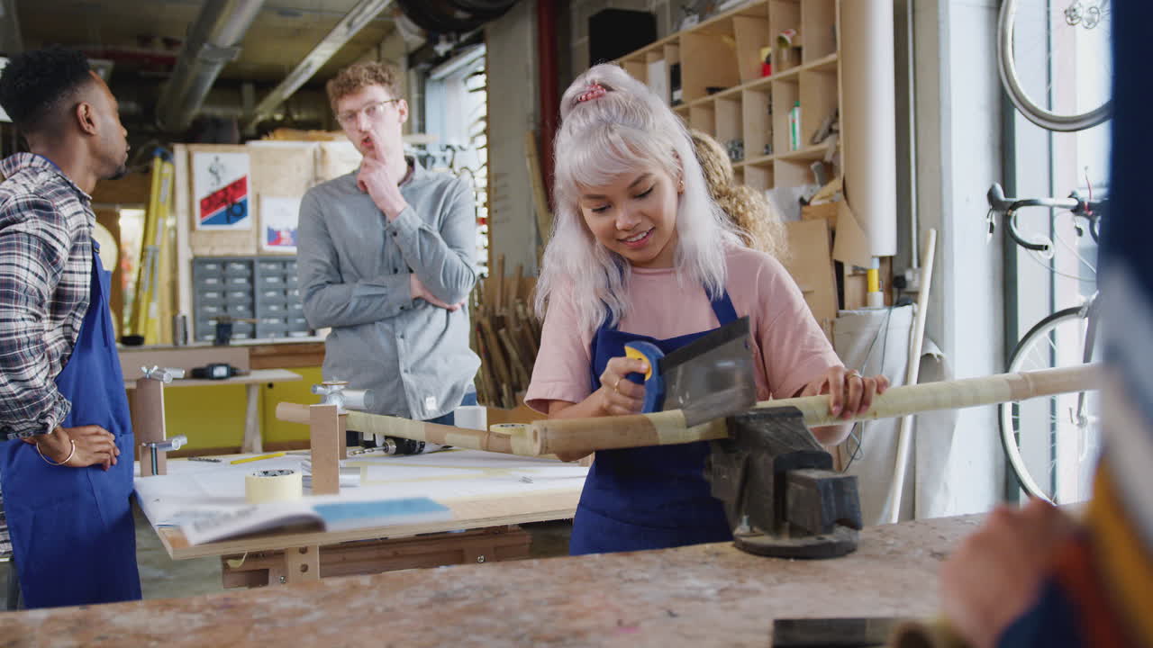 мультикультурная команда стажеров в мастерской собирает ручной велосипедный каркас вместе