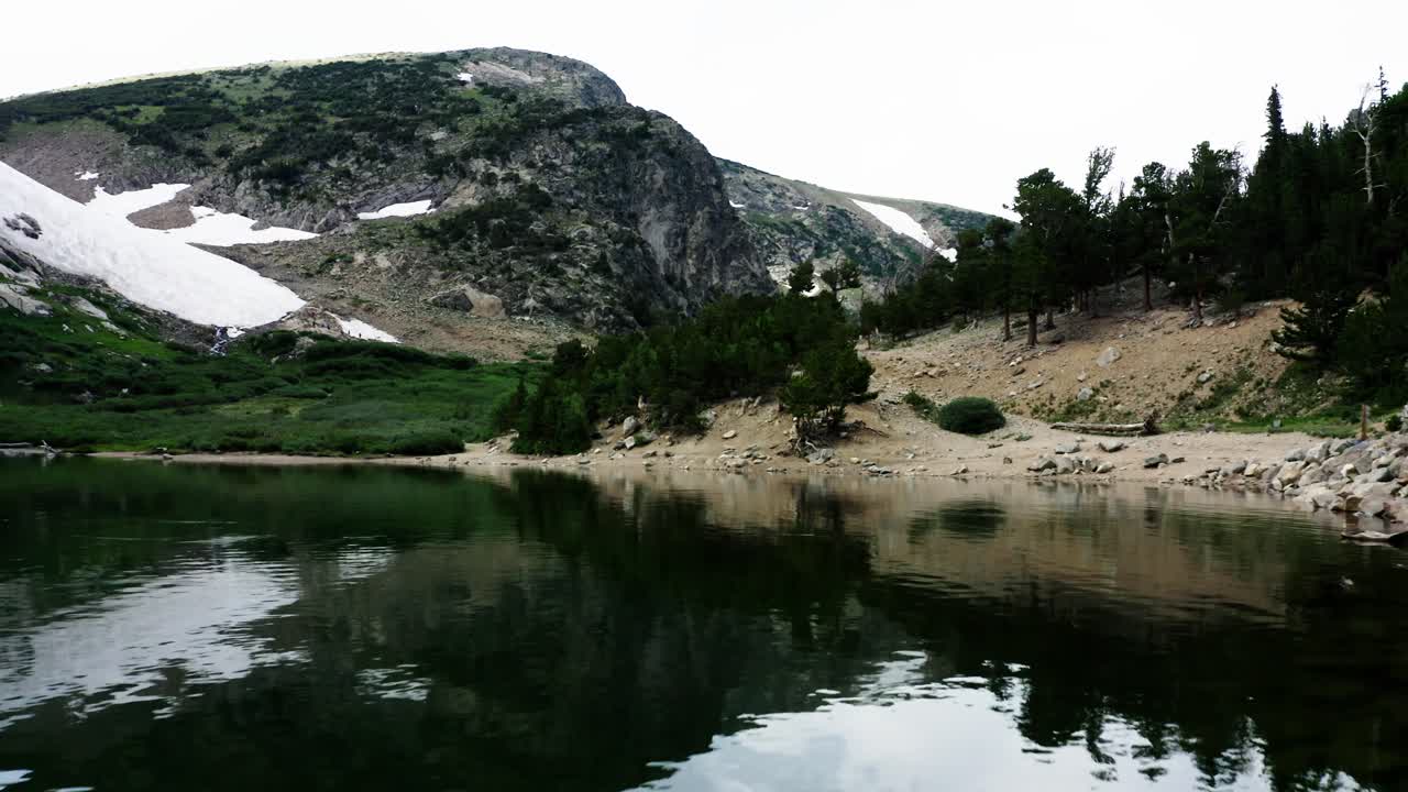 Moving over the shores of Saint Mary's Lake in the Rocky Mountains with a glacial snowfield in the distance