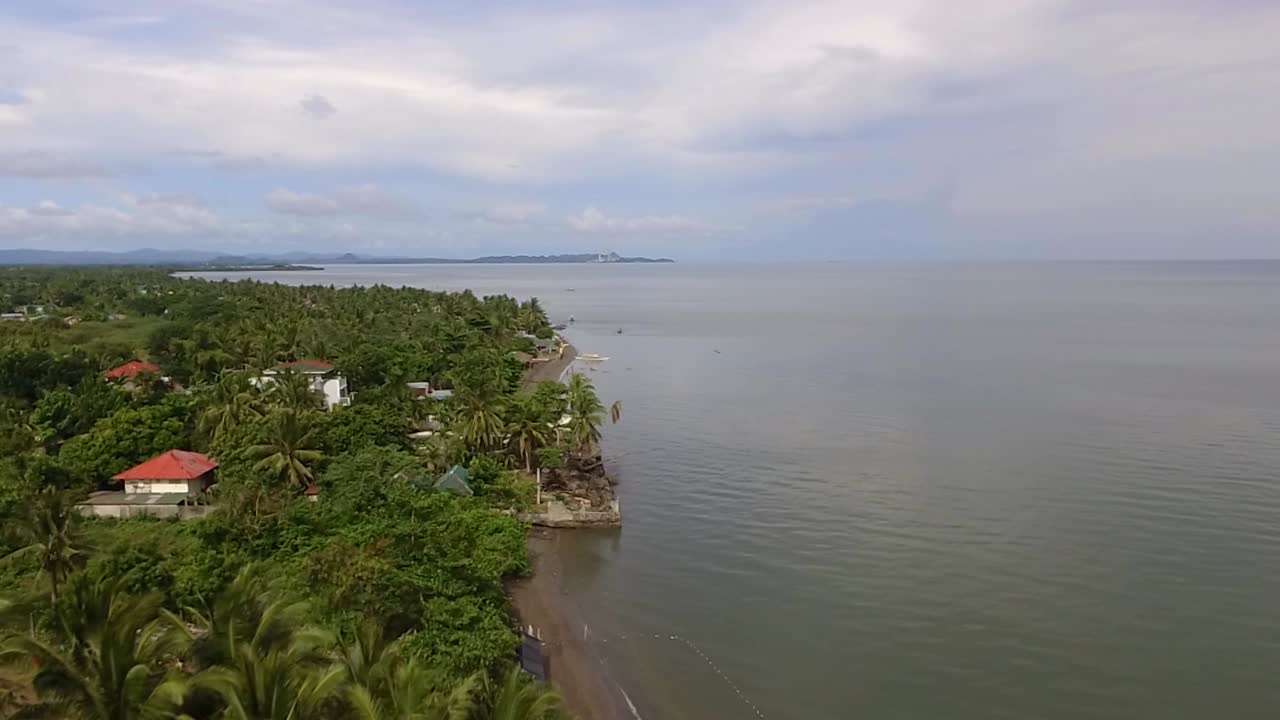 casas de asentamiento y establecimientos a lo largo de la playa de arena y hermoso mar tranquilo en un día nublado, drone aéreo