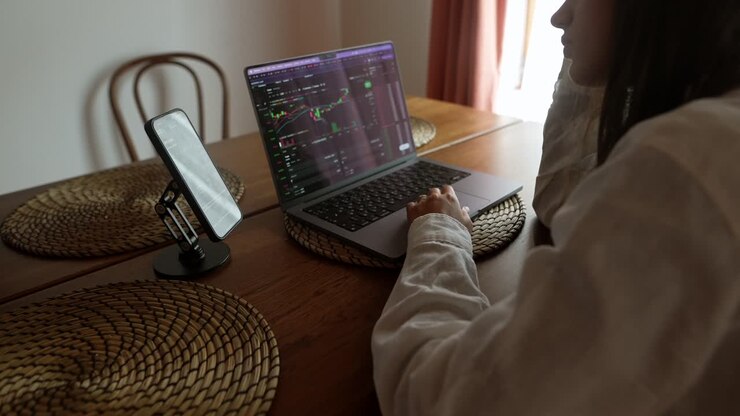 женщина, работающая из дома на биржевых диаграммах.