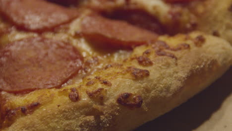 moving over pizza crust of pepperoni pizza - extreme close