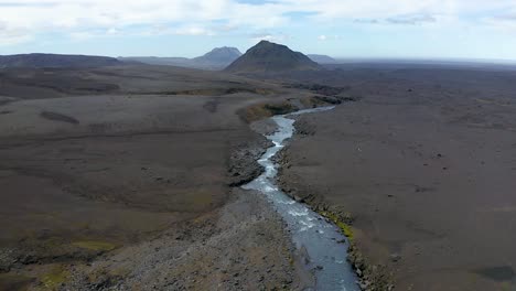 flying a drone backwards along a river with cold and fresh water in the highlands of iceland, revealing the pure icelandic water. copy space to the sides.