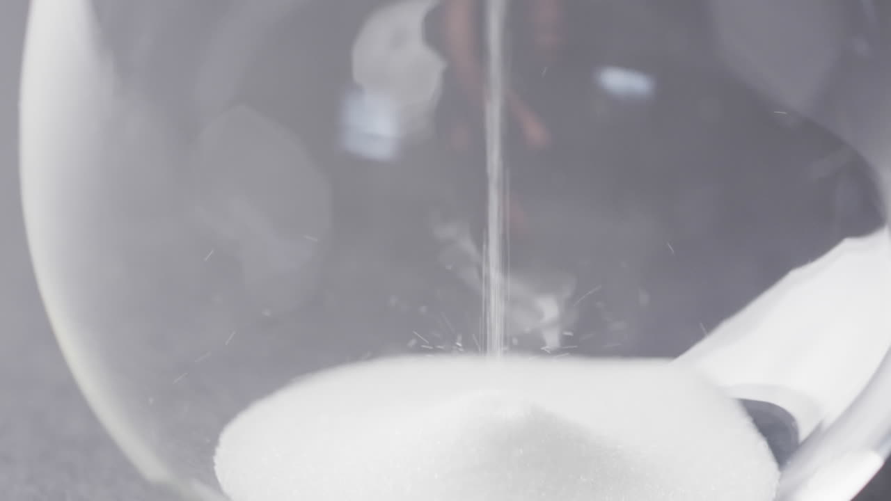 모래를  ⁇ 는 모래시계의 클로즈업 비디오, 검은 바탕에 공간을 복사