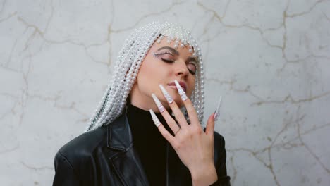 fashionable woman with pearl headpiece and embellished nails