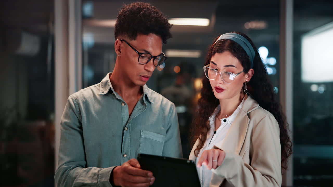 Business Colleagues Discussing Project on Tablet at Night