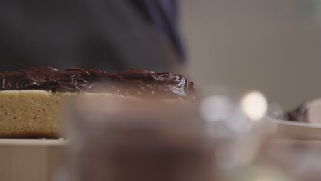 close up of man in kitchen at home adding chocolate filling to freshly baked cake on work surface 1