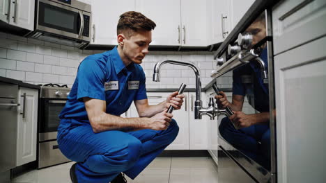 plumber repairing kitchen faucet