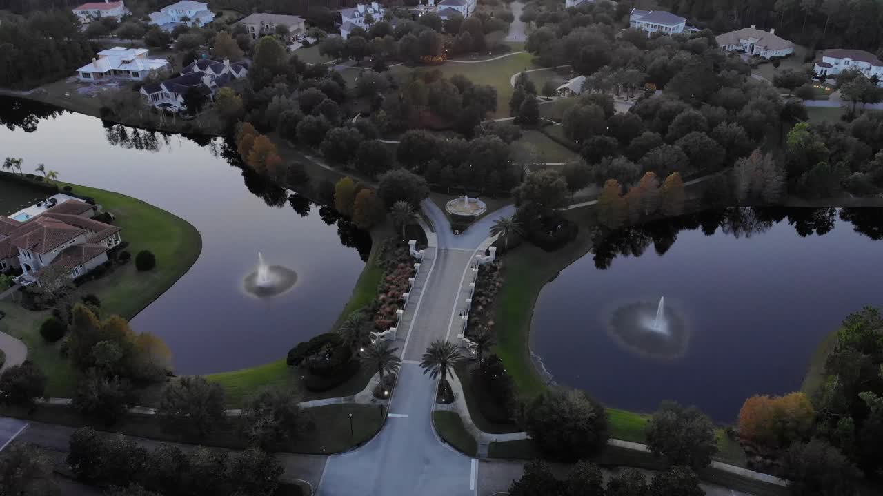 석양에 두껍고 개발되지 않은 임업으로 둘러싸인 한적한 고급 노스 플로리다 지역으로 이어지는 다리의 공중 샷