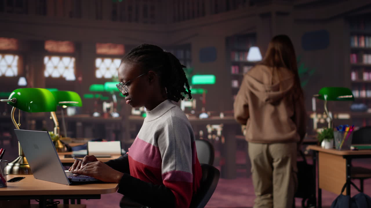 Vertical video young scholar focuses on exam preparations in the campus library with colleague