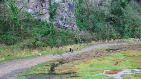 toma aérea de dos personas caminando por un sendero en el campo