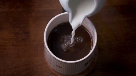 Super-slow-motion-of-cream-splashing-into-a-warm-cup-of-coffee