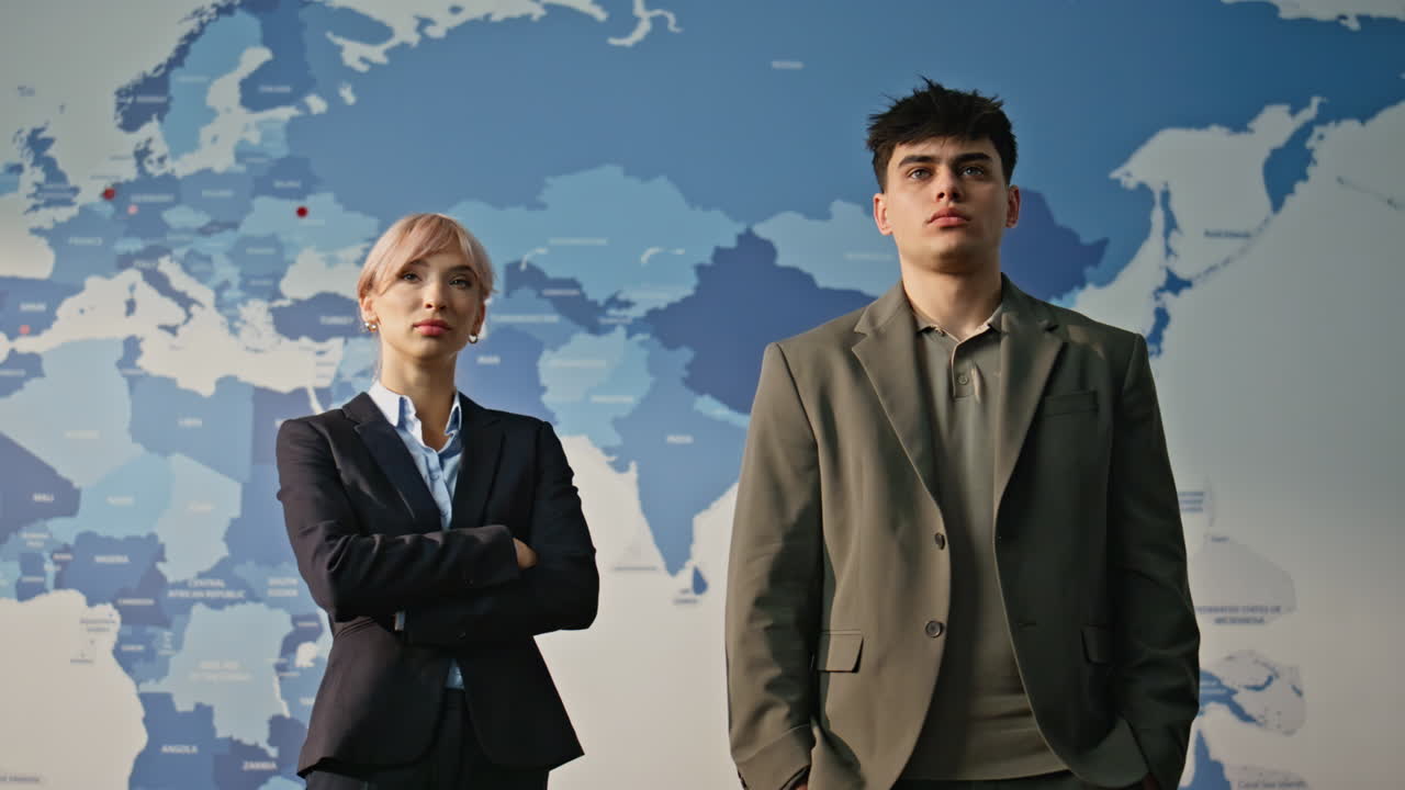 Two business analysts posing together in blue world map background portrait