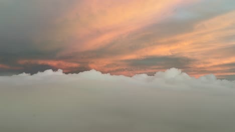 pov flying through a pastel color sky with golden clouds illuminated by sunrise light. a pilot’s perspective taken from the cockpit of a jet .4k 60fps