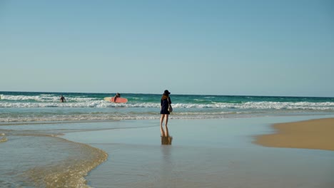 Weiblicher-Junger-Asiatischer-Tourist,-Der-Am-Strand-Auf-Stradbroke-Island,-Brisbane,-Australien-Spaziert