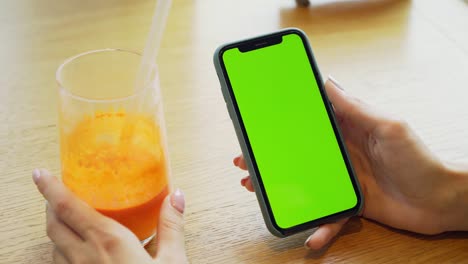 woman holding smartphone with green screen