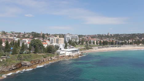 coogee surf life saving club at coogee beach with eastern suburbs in background in sydney, new south wales, australia