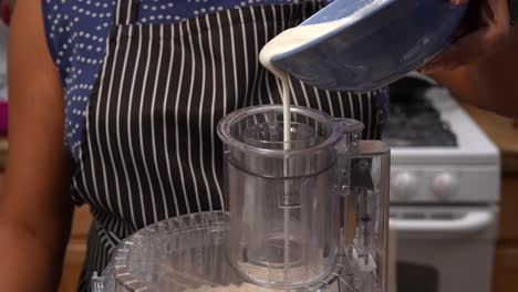 pouring yogurt into a flour mixture to make bhatura bread dough - chana masala series