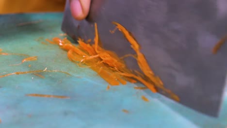 a detailed close-up shot of a sharp knife finely chopping a carrot on a cutting board. the scene captures precision cutting, perfect for food preparation, culinary tutorials, or cooking content.