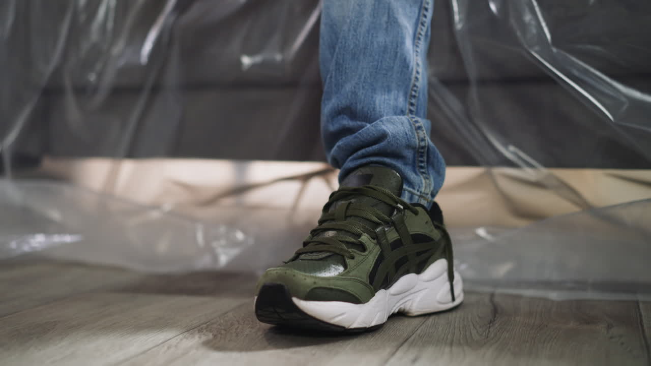 남자가 음악 리 ⁇ 에 발을  ⁇ 고 포일 된 소파에  ⁇ 고 있습니다.