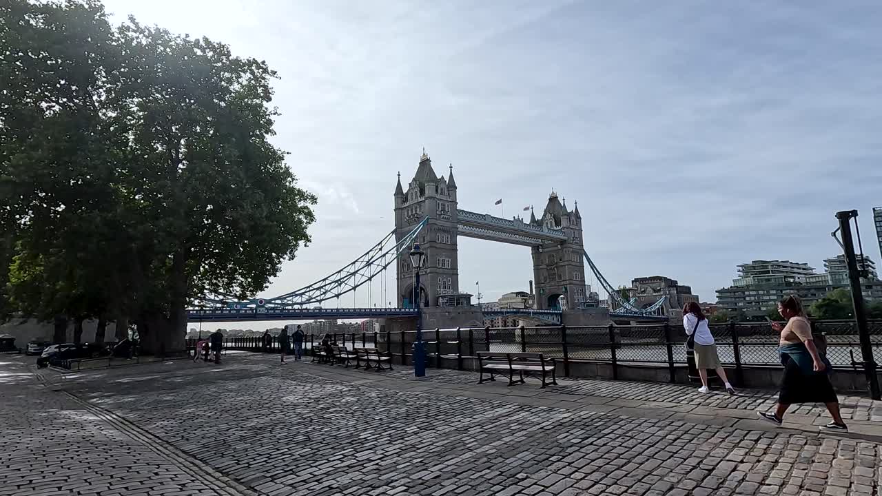 런던의 타워 브리지 근처에서 산책하는 관광객들