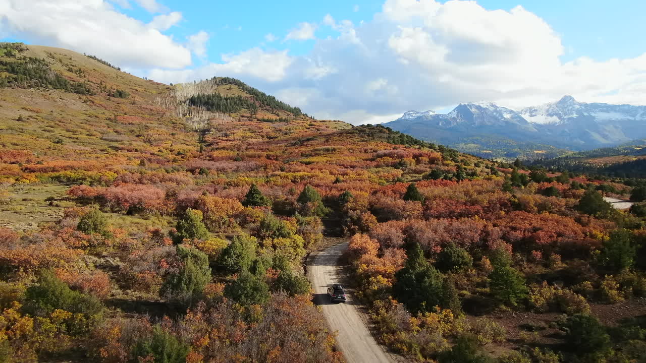 Follow car Mount Sniffels Wilderness Colorful Colorado Million Dollar Highway Dallas Range aerial cinematic drone cloudy autumn fall colors San Juans Ridgway Ralph Lauren Ranch 14er forward follow
