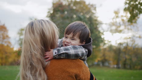 mamá y hijo están caminando en el parque de otoño