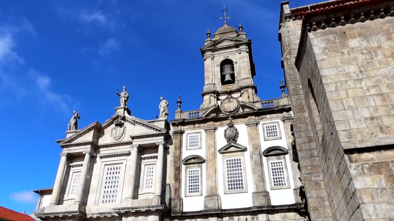 Tilt down shot of Saint Francis Church with bell tower and white facade, Porto